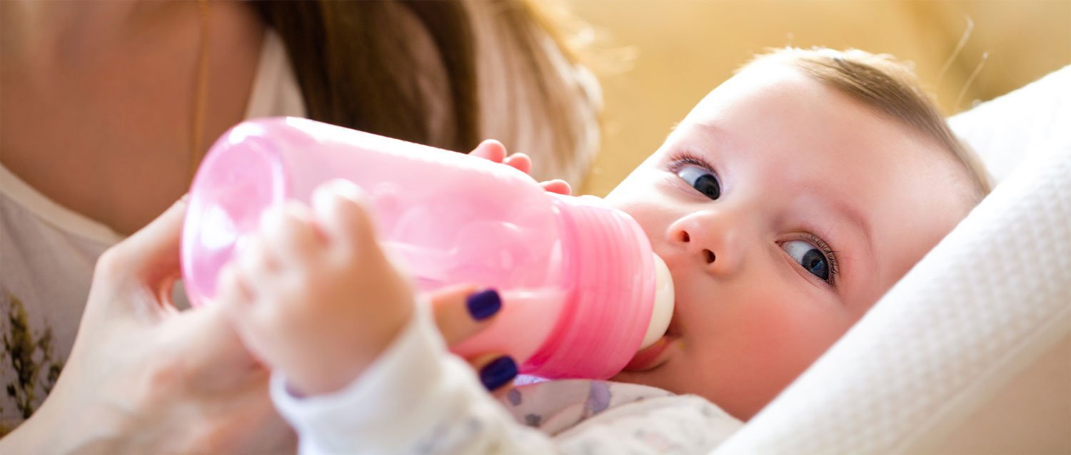 Babykostwärmer: Baby trinkt aus warmer Flasche